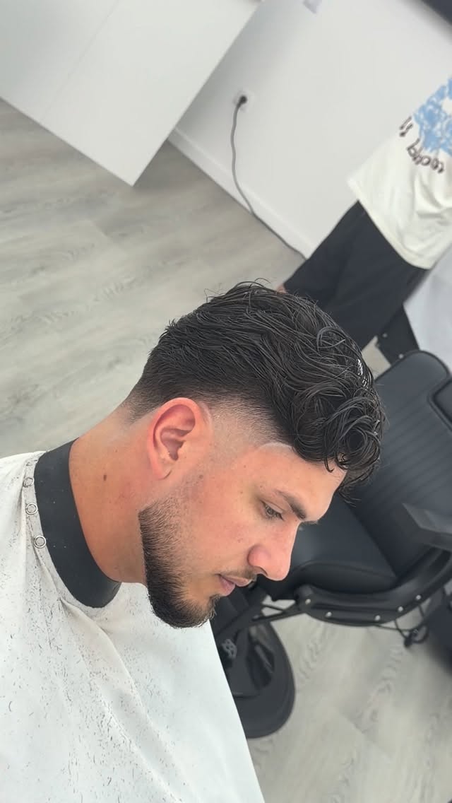 Corte ondulado com fade nas laterais e barba aparada